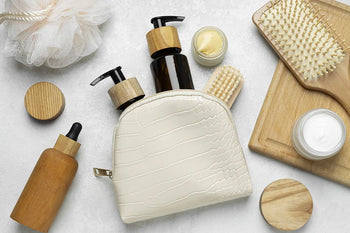 Trousse beauté naturelle avec soins visage, corps et cheveux en flacons, brosse et accessoires éco-responsables.
